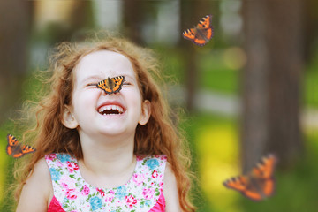 Laughing funny girl with a butterfly on his nose.
