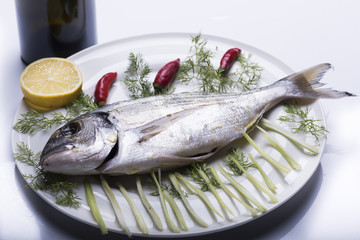bream topped on a white plate ready to be cooked