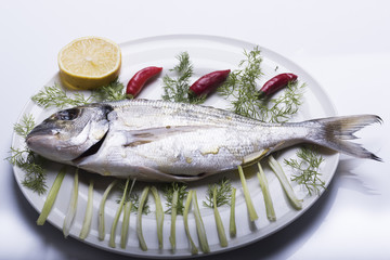 bream topped on a white plate ready to be cooked