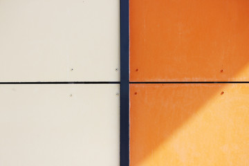 The wall of the house, trimmed with colorful panels, painted in bright colors. Orange and beige