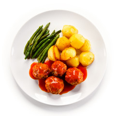 Roast meatballs with potatoes and green bean on white background