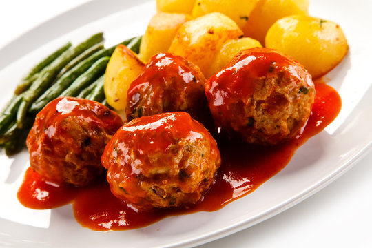 Roast meatballs with potatoes and green bean on white background