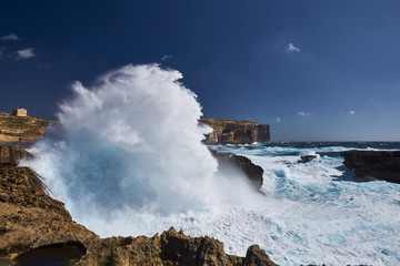 Fototapeta na wymiar Rocky coastline near former Azure Window attraction, with big, stormy waves. Island Gozo, Malta .