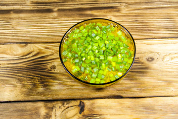 Fresh vegetable soup in glass bowl on wooden table. Top view