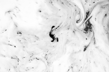 Black and white background with ink on milk texture