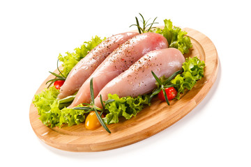 Fresh raw chicken fillet on wooden cutting board on white background
