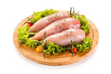 Fresh raw chicken fillet on wooden cutting board on white background