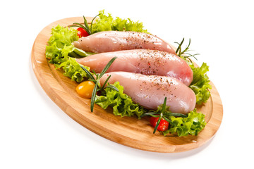 Fresh raw chicken fillet on wooden cutting board on white background