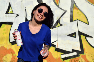 Portrait of an emotional young girl with black hair and piercings. Photo of a girl with aerosol...