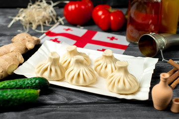 Khinkali on a wooden table with vegetables