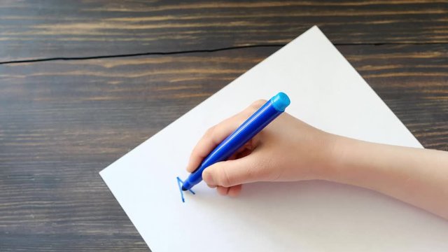 Child's hand writing letters, closeup shot