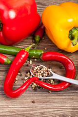 Sweet and spicy peppers on wooden background in studio photo. Raw healthy food