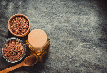 linseed oil in bottle and flax seeds on table