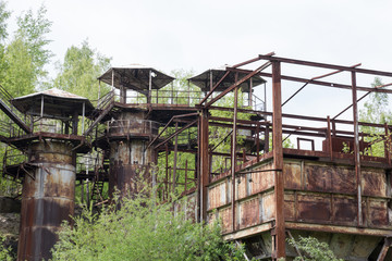 Fototapeta na wymiar Old iron rusty industrial construction in the middle of the forest