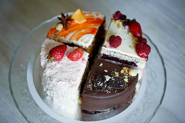 The different pieces of the cake smoothly rotate on the base.There is chocolate, carrot, yogurt and berries.