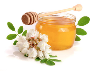 Jar of honey with flowers of acacia isolated on white background