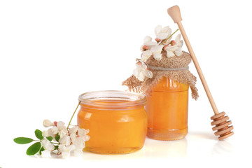 Jar of honey with flowers of acacia isolated on white background