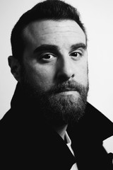 Portrait of a young handsome bearded model. Black and white photo.
