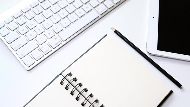 Female hand is taking a pencil and drawing a line in the notebook