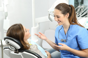 Dentist explaining procedure to a patient - obrazy, fototapety, plakaty