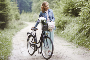 Fototapeta premium Woman with bike walking in forest