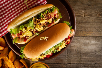 Tasty classic traditional hot dog on wooden board on wooden table background. Top View.