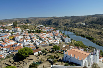 A down angle of Mertola village. In the distance you can see an enormous bridge towering over the river heading for the mountainous land surroudning the village.