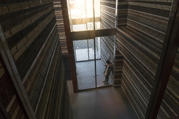 A woman waiting at the entrance of dark building