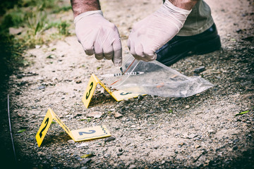 Crime scene investigation, picking up the tossed syringe and putting it to the plastic bag