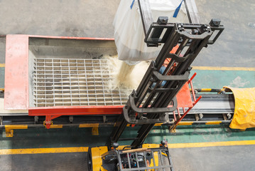 worker pouring seed from big bag rice processing
