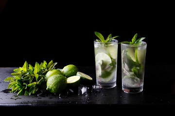 Mojito traditional summer refreshing cocktail alcohol drink in glass, bar preparation soda water beverage, lime juice, mint leaves, sugar, and rum