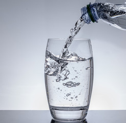 Wasser in das Glas aus der Flasche einfüllen zum trinken