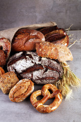 Different kinds of bread rolls on white board from above. Kitchen or bakery poster design.