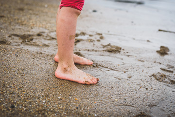 Children playing barefoot sandy beach of Atlantic ocean in Spain.
