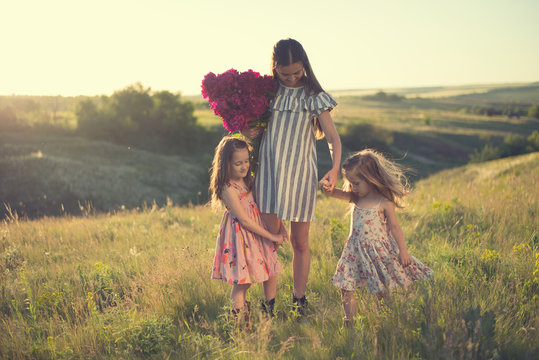 family portrait of mother with two daughters during nature stroll