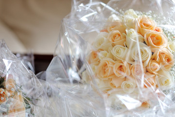 Bridal white and pink roses bouquet still wrapped in plastic