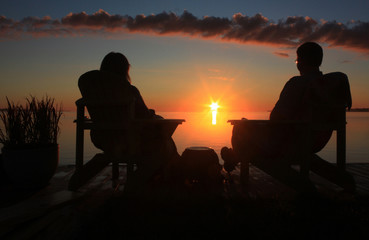 Fototapeta na wymiar Couple watching the sunrise over the ocean.