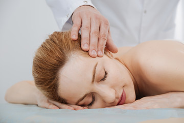 Obraz na płótnie Canvas Gentle experienced doctor massaging patients temples
