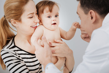 Positive dedicated pediatrician preparing kid for examination