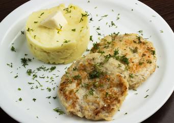 Homemade fried meatballs with mashed potatoes on white plate close up