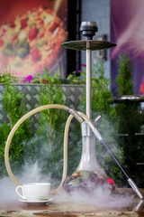 Hookah on a wooden table on the summer terrace