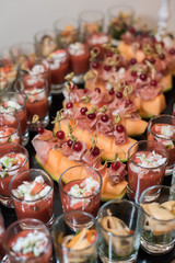 Cold seafood snacks in glasses and plates