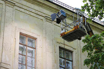 Fototapeta na wymiar A special projector on the lift lights the window of the Gatchina Palace when shooting a feature film outside the building.