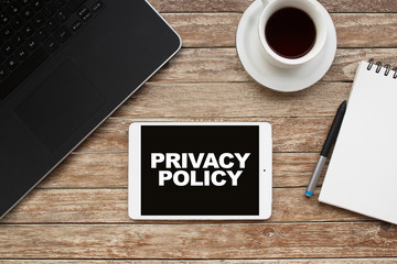Tablet on desktop with privacy policy text.