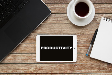 Fototapeta na wymiar Tablet on desktop with productivity text.