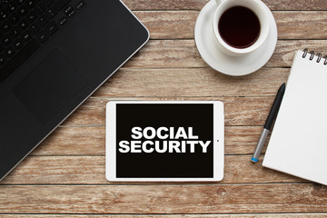 Tablet on desktop with social security text.