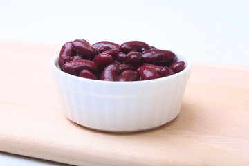 Heap of canned red kidney beans in the sauce in white bowl. vegetarian food. Phaseolus vulgaris.