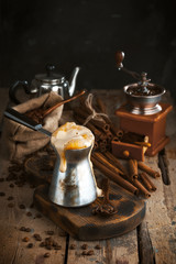 Turk, including freshly brewed coffee, a sack of coffee beans, vintage coffee grinder, cinnamon sticks.