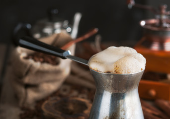 Turk, including freshly brewed coffee, a sack of coffee beans, vintage coffee grinder, cinnamon sticks.