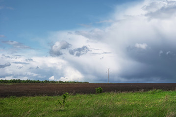 Naklejka na ściany i meble Beautiful rain clouds over the green fields of Russia